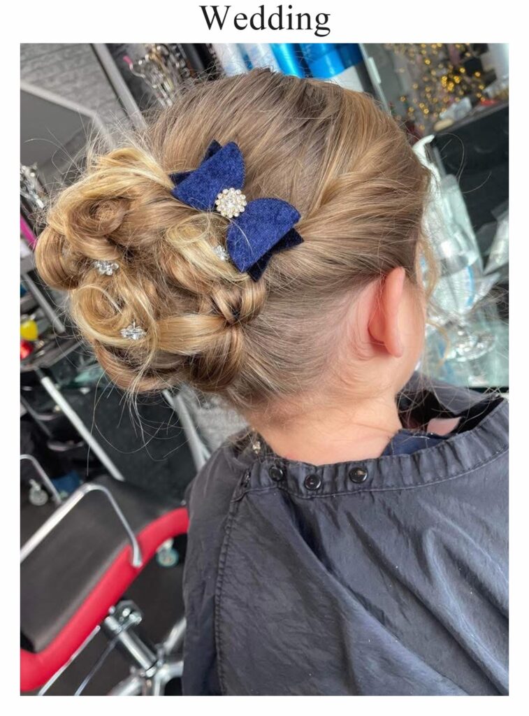 Wedding hair: a child’s curled updo with a navy bow