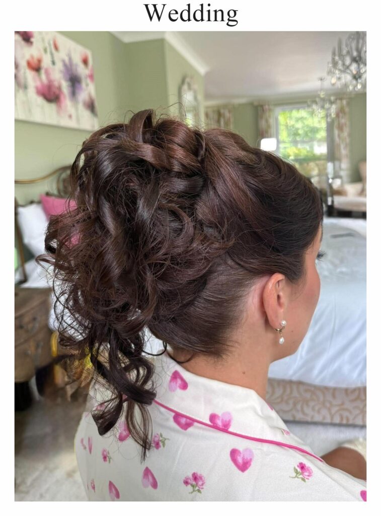 Wedding hair: a loose updo of dark curls with face-framing tendrils