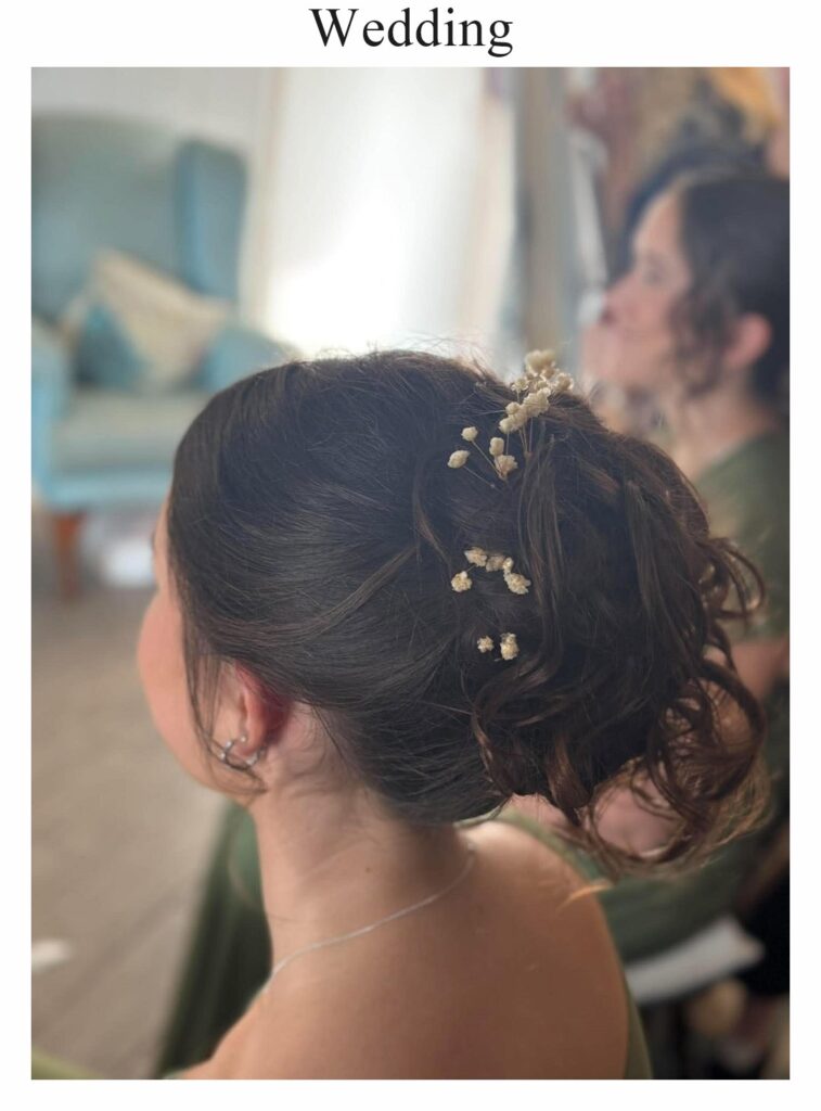 Wedding hair: a soft dark updo with sprigs of gypsophila